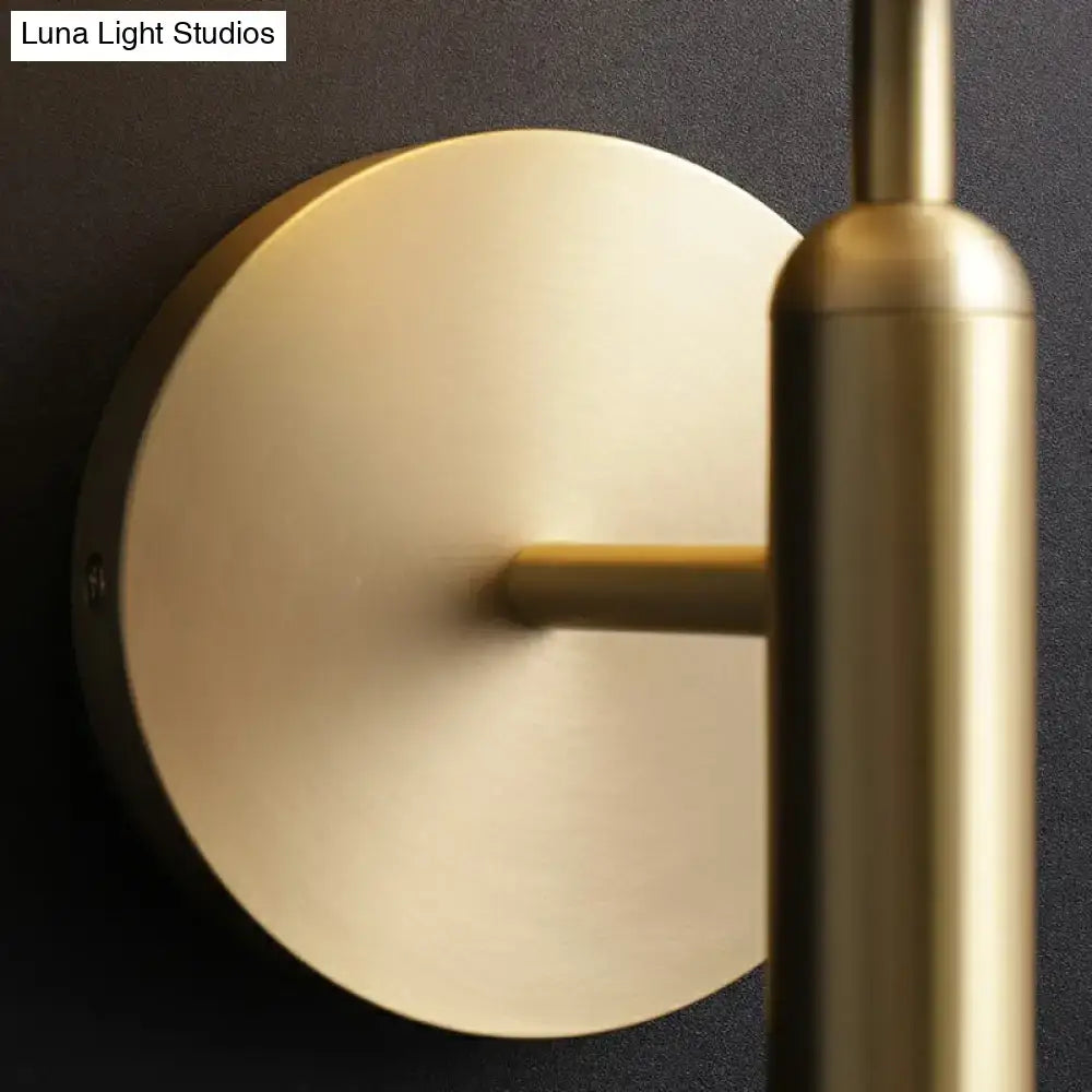 Minimalist brass wall sconce with cream glass shade and circular backplate for living room lighting