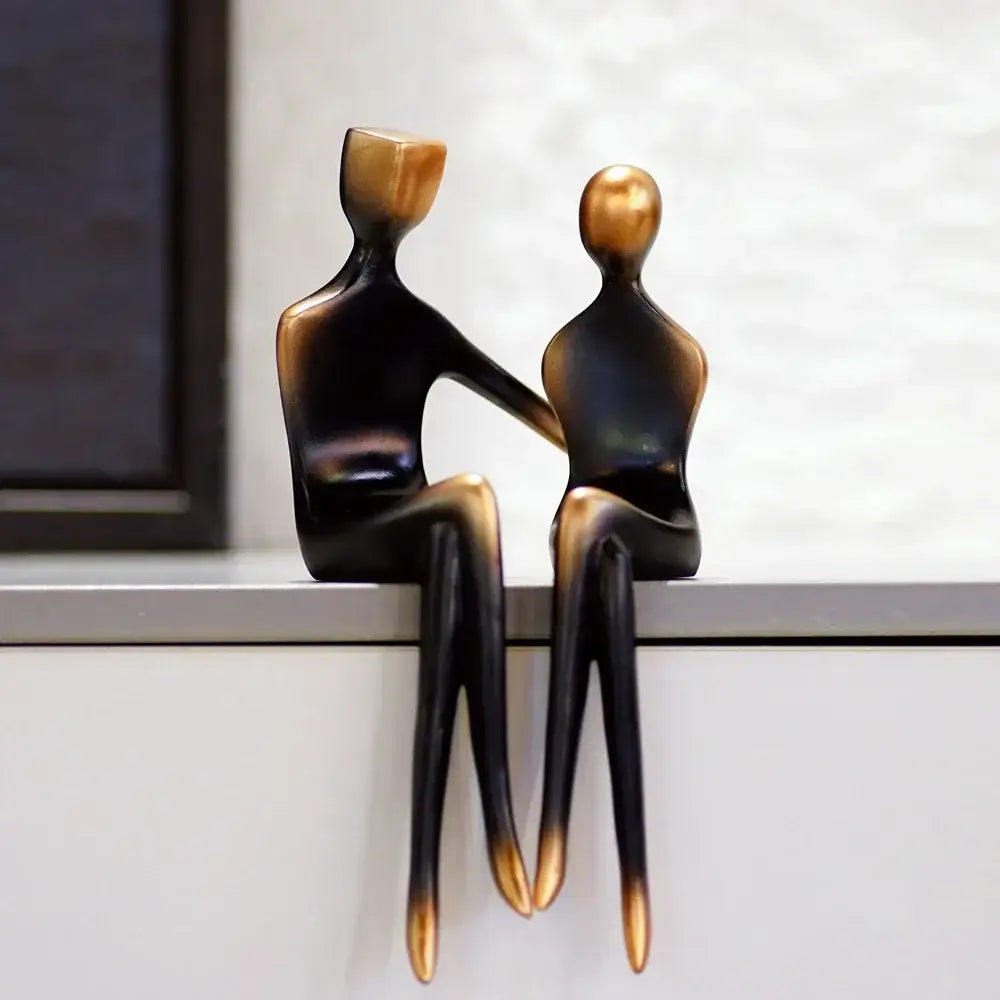 Two elegant resin couple sculptures in minimalist black and bronze resin decorbites style for bedroom decor