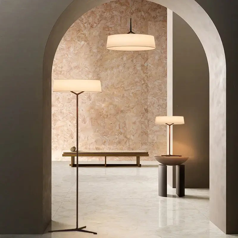 Minimalist bronze italian design floor lamp with cylindrical off-white fabric shade and slender black metal frame by decorbites italian design