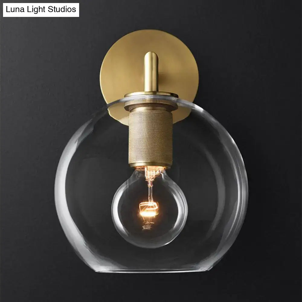 DecorBites minimalist bronze wall sconce with brushed brass backplate, textured stem, clear glass shade, and exposed light bulb