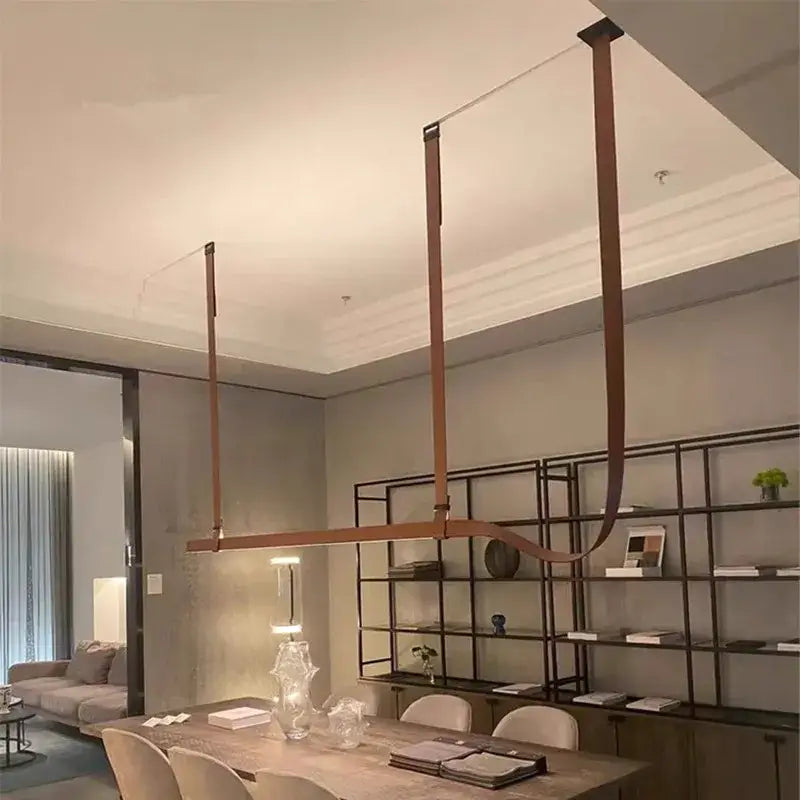 Modern copper-toned pendant lamp with sleek curved metal arms for minimalist brown leather hanging clothes drying rack decorbites belt