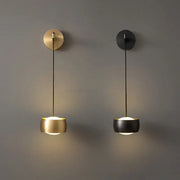 Two minimalist wall lamps with brushed brass and matte black cylindrical shades featuring copper adjustable led cords for bedroom decorbites copper adjustable lighting