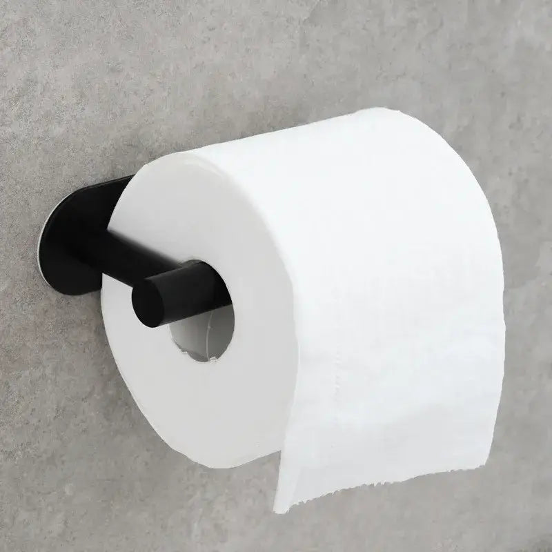 Black matte tissue holder with white roll mounted, contrasting with minimalist brushed gold stainless steel bathroom stand