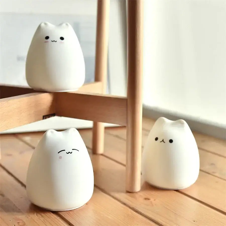 Three white ceramic cat silicone led night lights with simple black facial features for decorbites cat silicone night light use