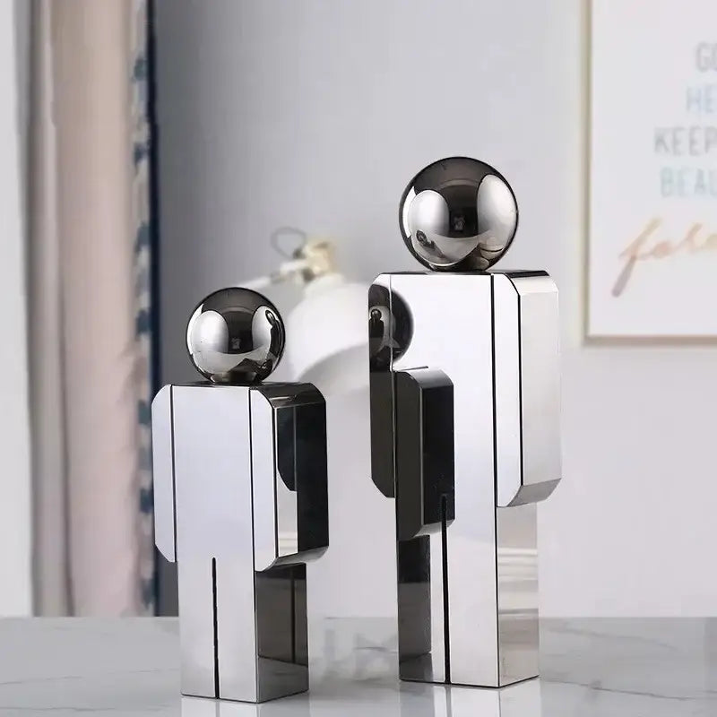 Two sleek decorbites crystal man statue figurines with chrome bodies and black spherical heads for living room decor
