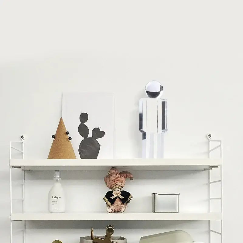 A sleek minimalist chrome decorbites crystal man statue with a spherical head and rectangular body for living room decor