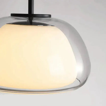 Minimalist clear glass jelly pendant lamp with warm glowing shade and black metal hardware for living room lighting