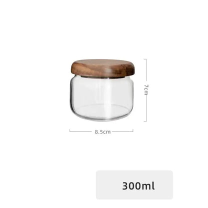 Minimalist clear glass storage jar with a smooth rounded acacia wood lid for kitchen organization