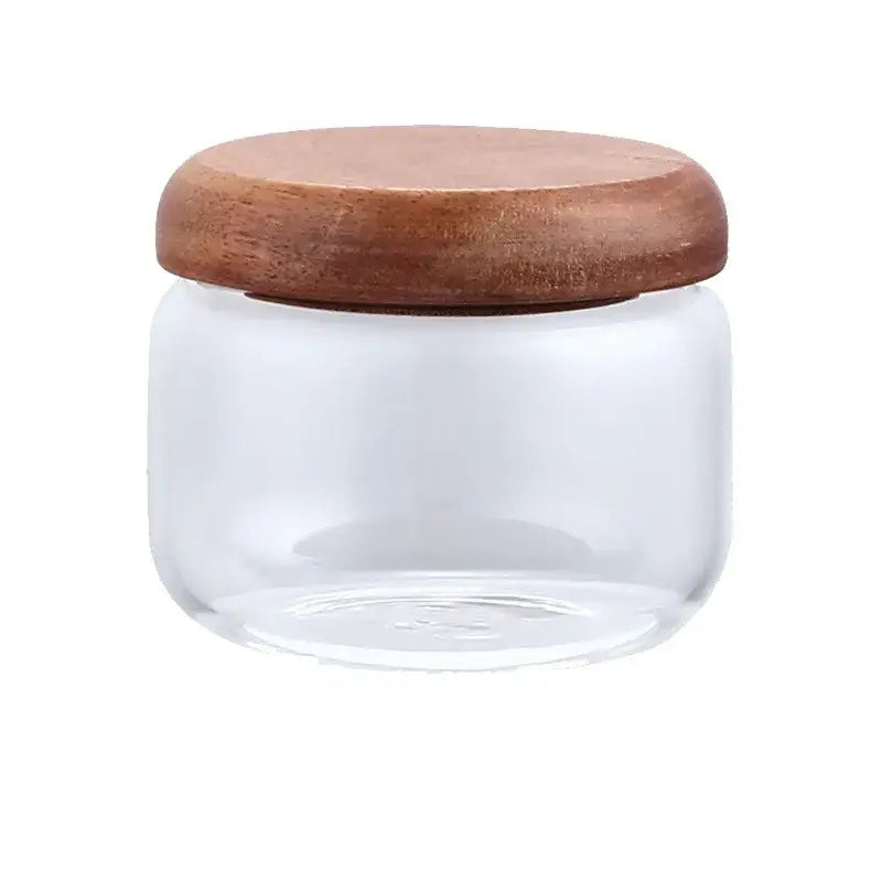 Minimalist clear glass storage jar with smooth rounded acacia wood lid for kitchen organization and storage