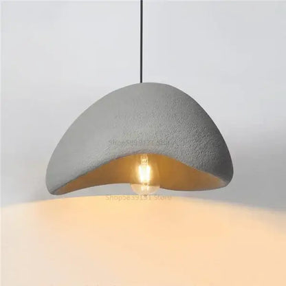 Gray concrete decorbites cobblestone pendant lights featuring a warm exposed bulb for minimalist dining room decor