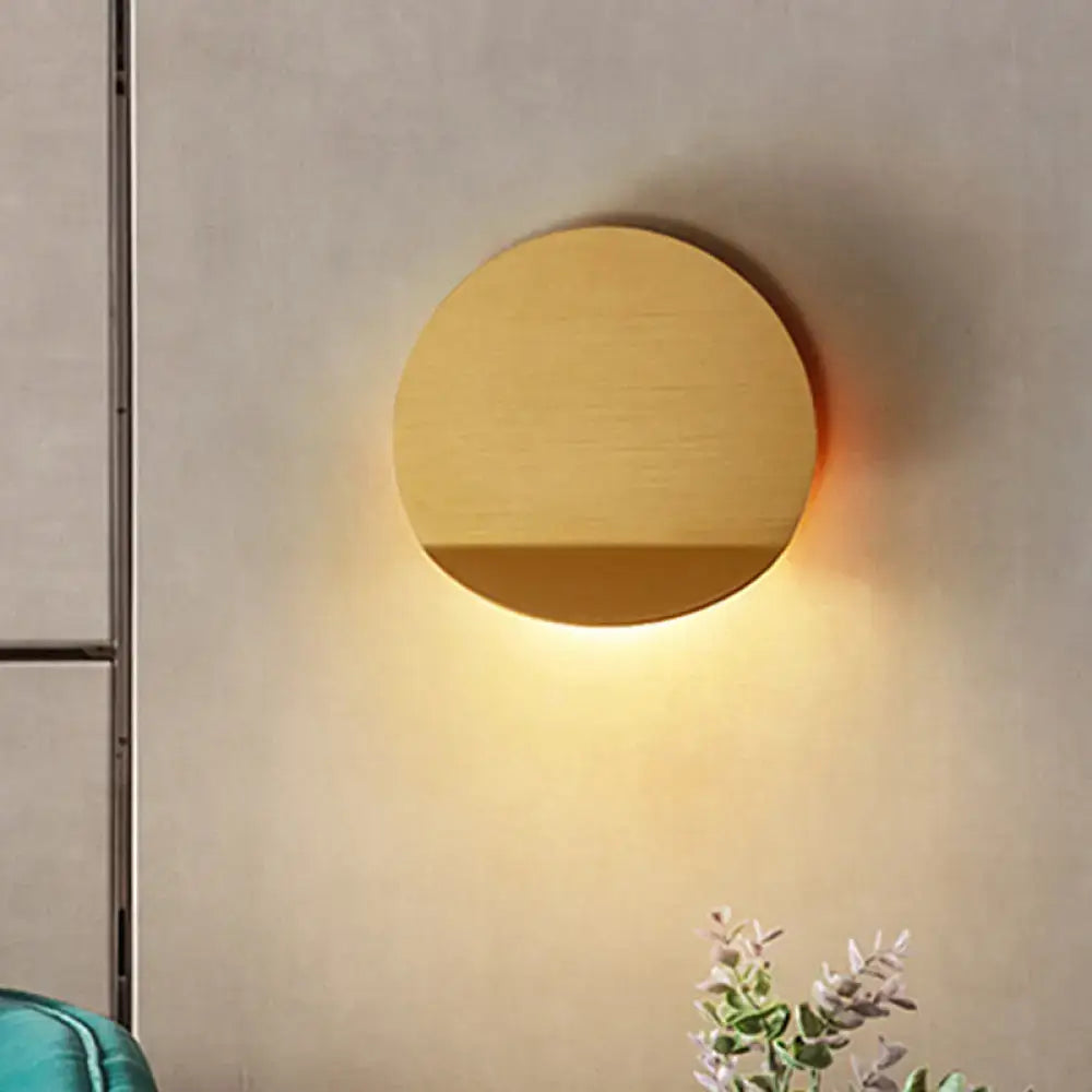 Minimalist copper sconce light with circular gold-toned wall mount and led bulb for bedroom lighting