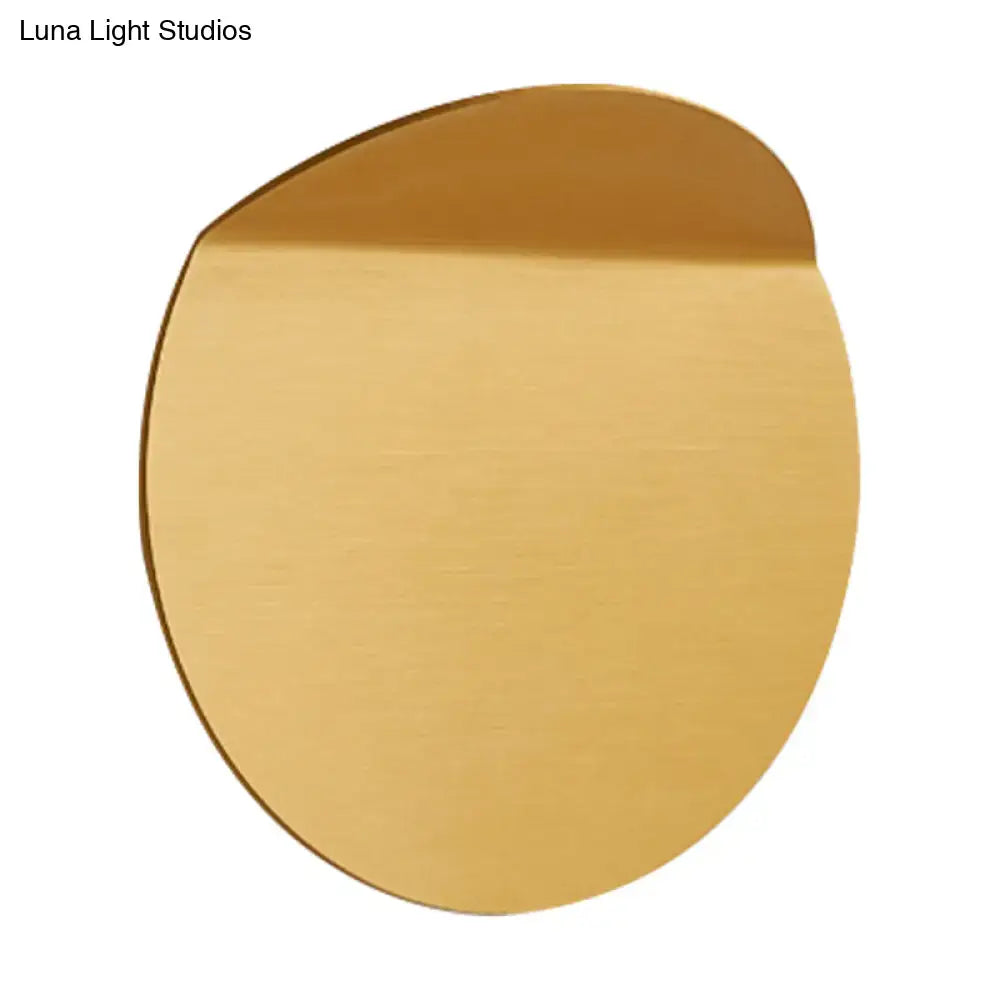 A sleek brushed gold circular minimalist copper sconce light wall mount with led bulb for bedroom use