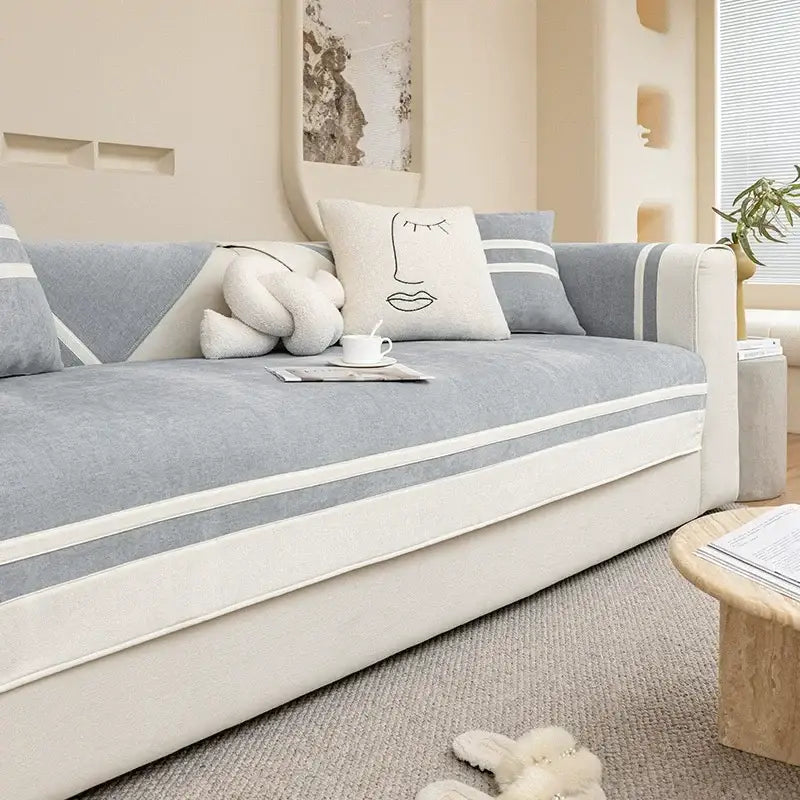 A modern gray and white sofa cover with textured fabric and minimalist cream and beige geometric stripes for living room cushions