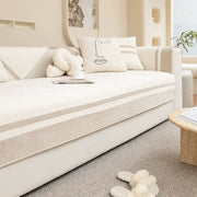 Cream-colored sofa with beige geometric trim and plush minimalist cushions featuring a geometric skirt sofa cover
