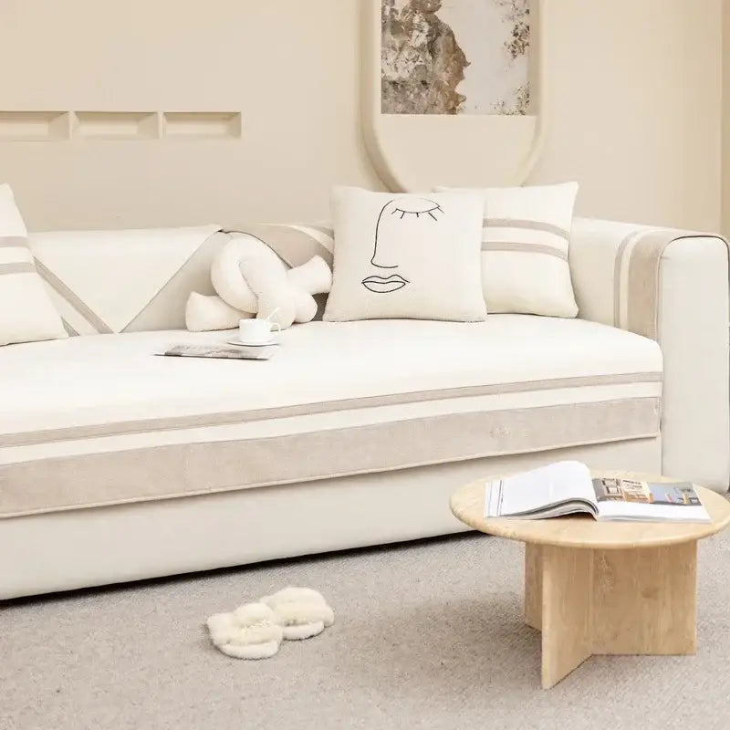 Minimalist cream-colored sofa with beige striped accents and geometric skirt cover for living room seating