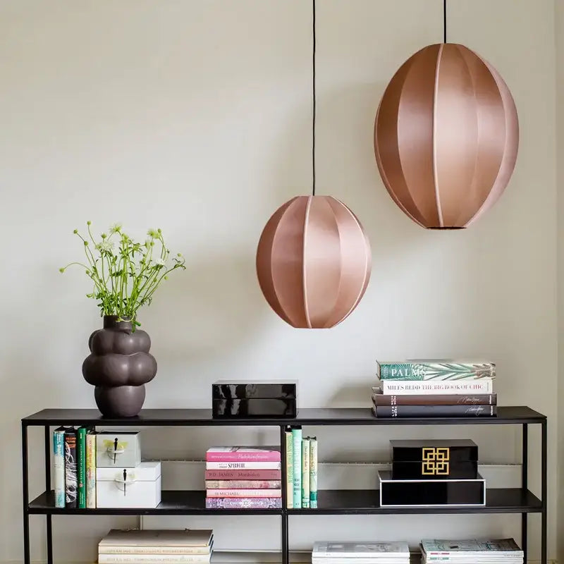 Two rose gold segmented spherical pendant lights complement minimalist cream and black geometric dining room decorbites danish pendant light