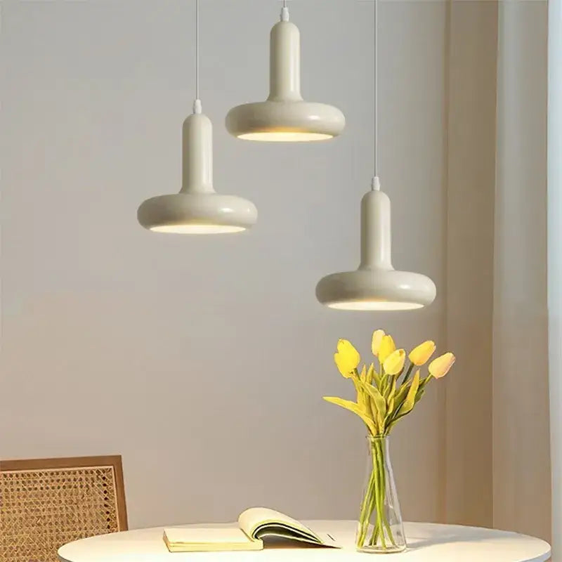 Three cream white ceramic pendant lights with a disc shaped minimalist design for dining room decorbites pendant light
