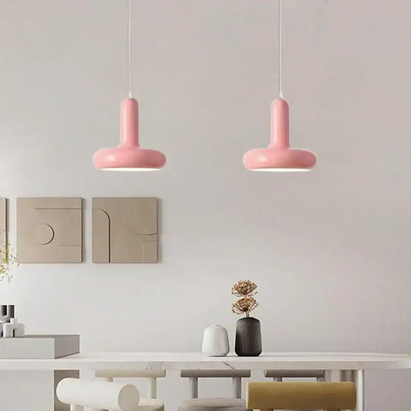 Two sleek matte pink pendant lights with minimalist design complement cream white decorbites disc shaped pendant light