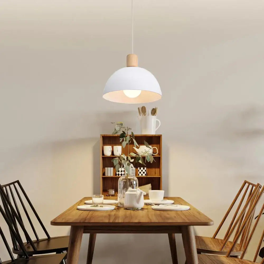 Minimalist pendant light with a crisp white dome and wood accent top for kitchen island lighting