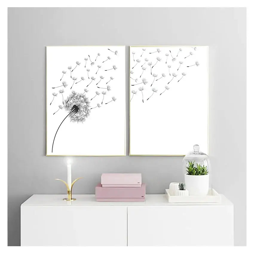 Two framed black-and-white minimalist dandelion canvas wall art pieces with thin gold frames by decorbites