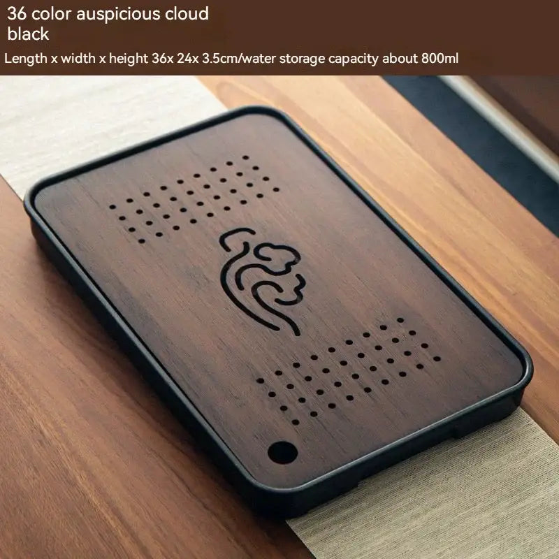 Minimalist dark brown and black bamboo tea tray with carved cloud design and perforated drainage holes for dining storage