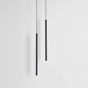 Two sleek black cylindrical decorbites black slim led pendant lamps hang vertically against a plain white background