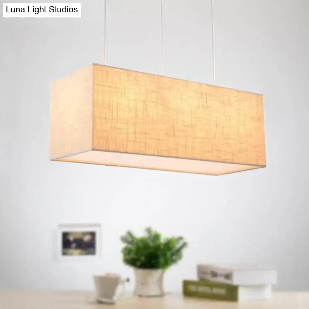 Minimalist flaxen rectangle island lighting with warm beige fabric shade suspended by thin cords for kitchen use