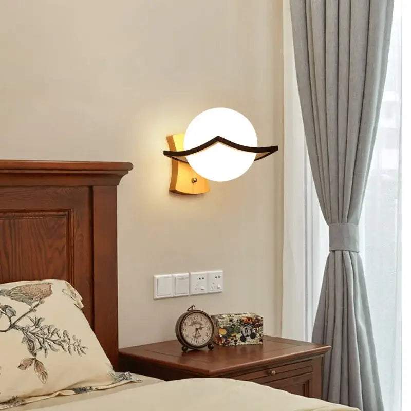 Minimalist frosted glass wooden wall lamp with round white globe and black metal accent on a warm wooden wall base