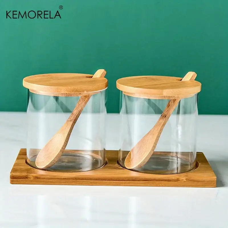 Minimalist glass spice jar set with bamboo lids and wooden spoons on a bamboo tray for kitchen organization