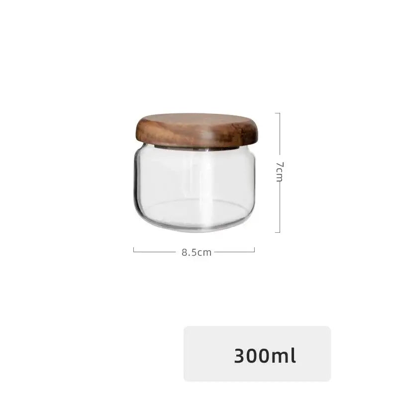 Minimalist glass spice jar with clear glass body and smooth rounded acacia wood lid for kitchen storage