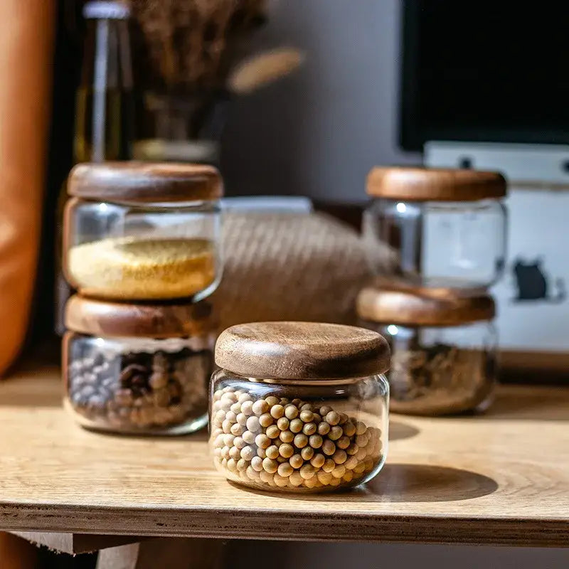 Minimalist glass spice jar with acacia wood lid featuring clear jars holding neatly arranged dried goods