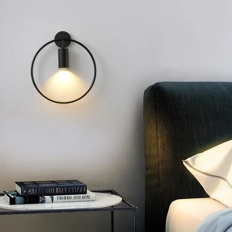 Black circular decorbites wall light with sleek minimalist design and adjustable angle for warm bedroom lighting
