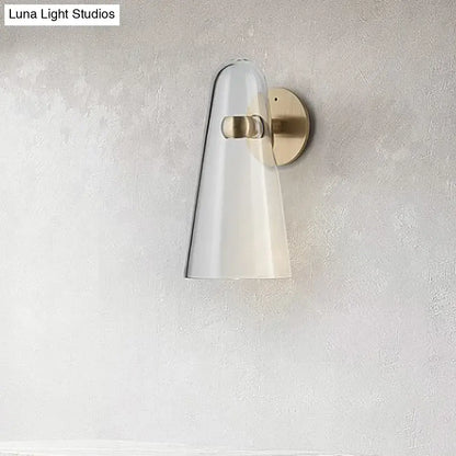 Minimalist wall mount lighting with a translucent white glass shade and brushed brass hardware for kitchen use