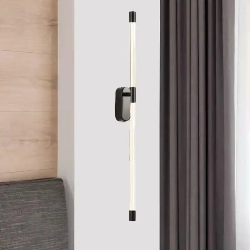 Modern black-framed decorbites acrylic line led wall lights with a sleek cylindrical design and warm white light for bedrooms