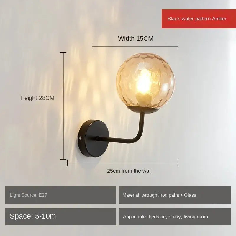 Minimalist gold and black wall lamp with amber decorbites glass ball led featuring black-water pattern on wrought iron arm
