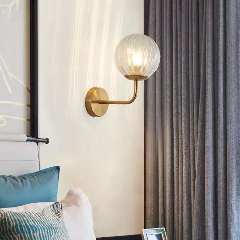 Minimalist gold and black glass ball led wall lamp with gold-toned sconce and textured translucent globe for decorbites