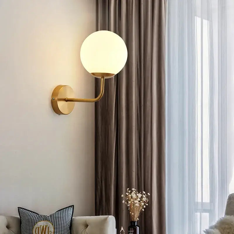 Minimalist gold wall lamp with decorbites glass ball frosted glass globe and black accents for bedroom lighting