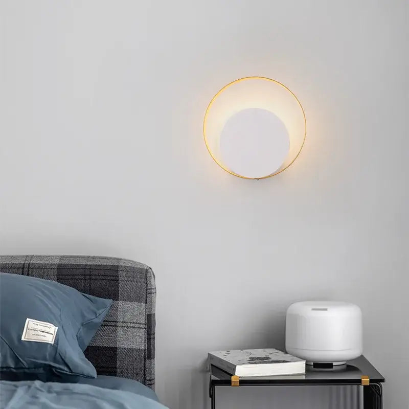 Minimalist gold and black led wall lamp with circular gold-toned ring and warm white central panel for living room