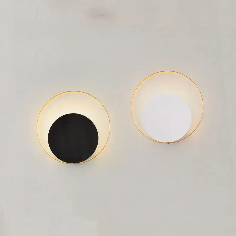 Minimalist gold and black led wall lamp with circular frames featuring one black disc and one soft white light