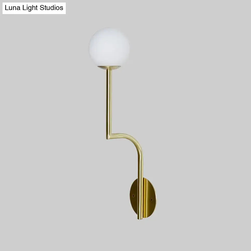 Minimalist gold wall sconce with long curved arm and frosted opal glass globe shade for bedroom lighting