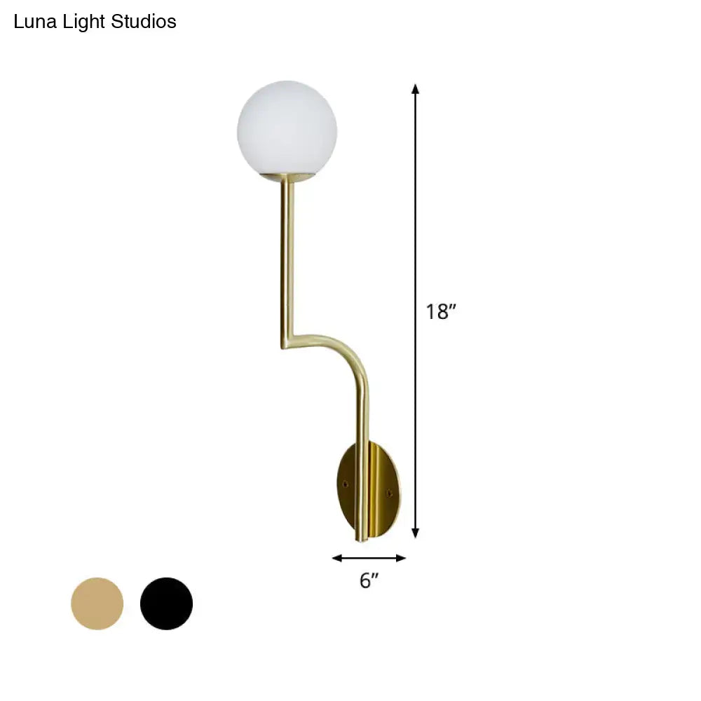 Minimalist gold and black opal glass wall sconce with long curved arm and frosted glass globe in brushed brass finish