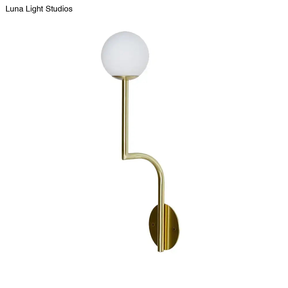 Minimalist gold wall sconce with long curved arm and opal glass sphere for elegant bedroom lighting