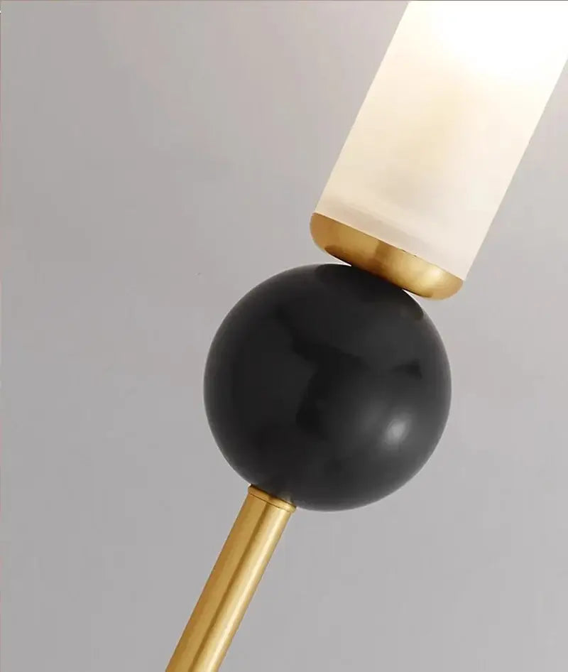 Minimalist wall lamp with black marble sphere gold-toned metal accents and frosted glass for copper wine corridor decorbites