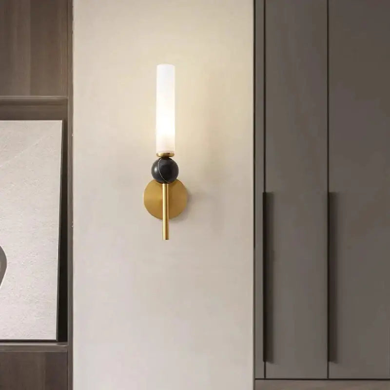 Minimalist gold copper wine corridor wall lamp featuring a frosted glass cylinder and black spherical accent by decorbites