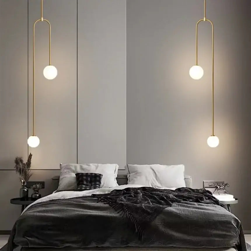 Minimalist gold double head glass ball pendant light with spherical frosted shades hanging symmetrically above bed