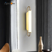 Minimalist gold elegant wall sconce with a sleek curved metal frame and frosted glass diffuser for bedroom decorbites elegant wall