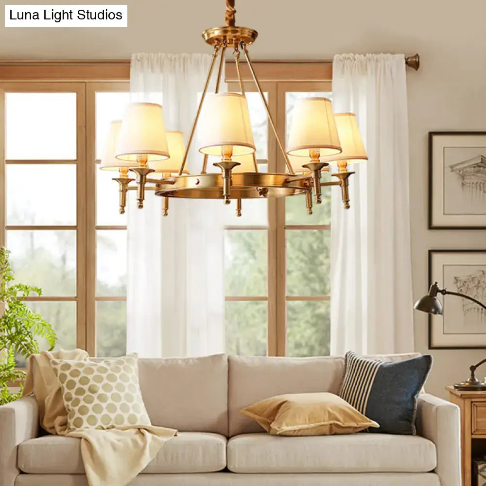 Brass-finished minimalist conical ceiling chandelier with six cream fabric bedroom shades for elegant lighting