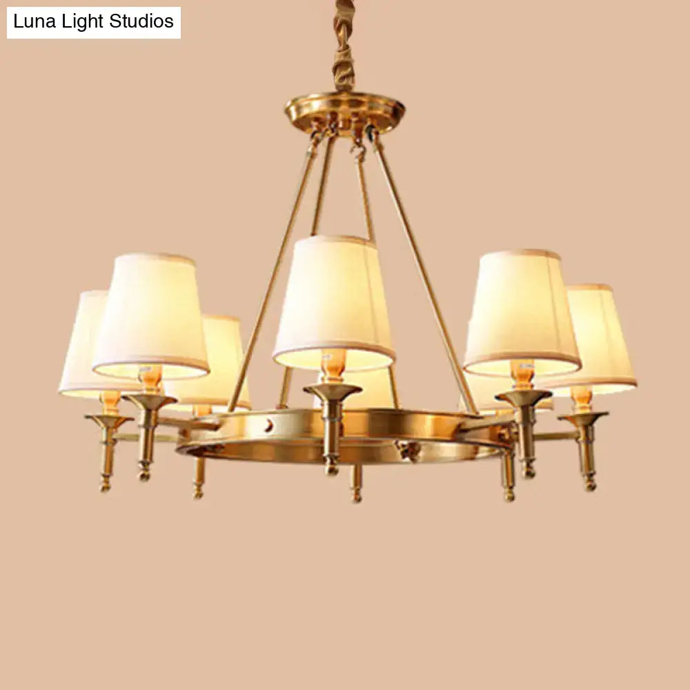 Brass-finished minimalist conical ceiling chandelier with six cream fabric bedroom shades for elegant lighting