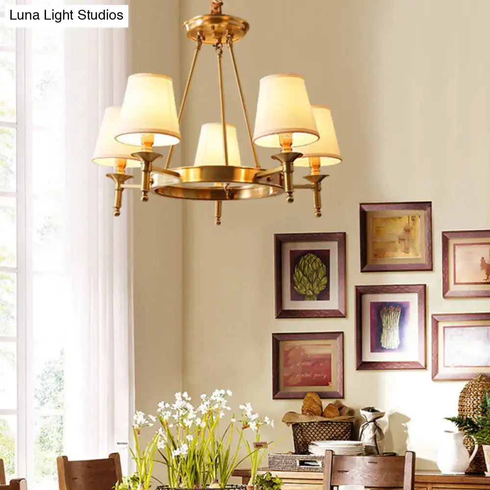 Brass minimalist conical ceiling chandelier with five cream fabric bedroom shades in a gold finish