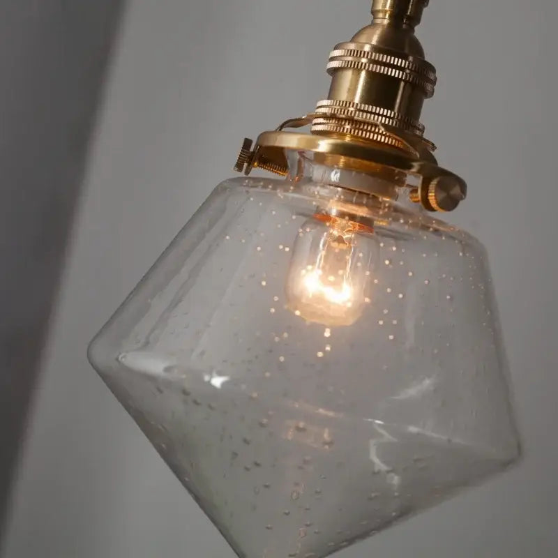 Minimalist gold faceted bubble glass led hanging light with brass fixture and exposed bulb for dining room use